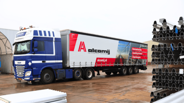 Vrachtwagen van Alcomij’s transporteur met trailer voorzien van Alcomij-reclame